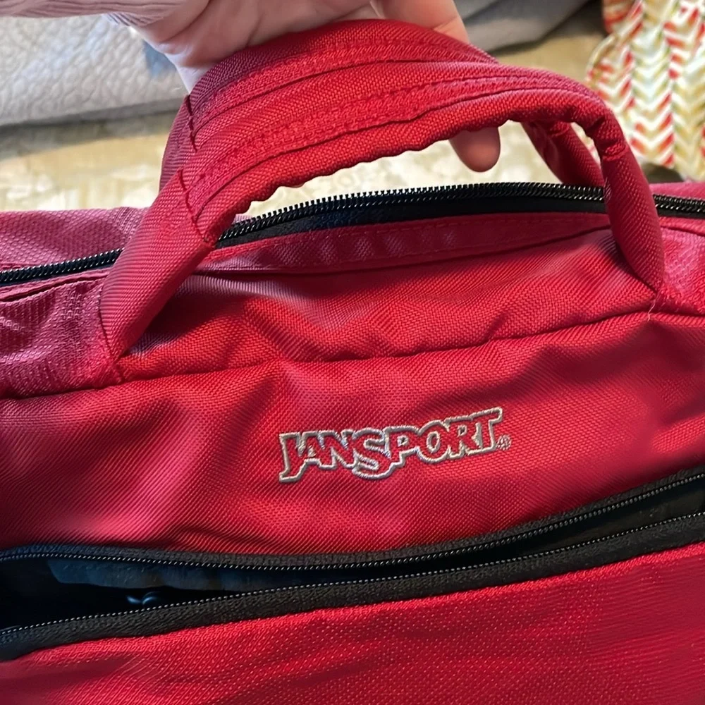 Red Jansport laptop messenger bag. Interior Velcro & outer zippered compartment
